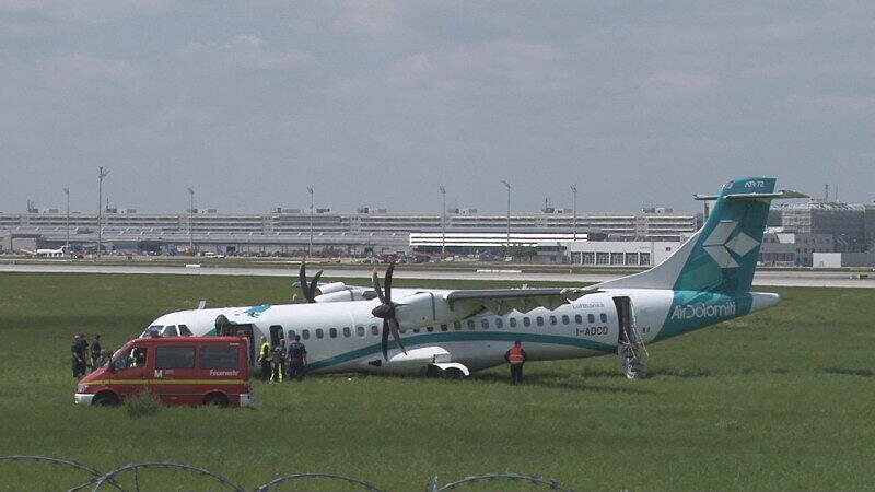 Mitarbeiter des Flughafens in München betrachten die Maschine der italienischen Fluggesellschaft, die am Donnerstag auf dem Münchner Flughafen notlanden musste. Das Flugzeug mit 62 Menschen an Bord hatte kurz nach dem Start in Richtung Venedig umdrehen müssen, weil sich Rauch in der Kabine entwickelt hatte. Bei der Landung wurden fünf Personen leicht verletzt, die Maschine kam neben der Landebahn zum Stehen.