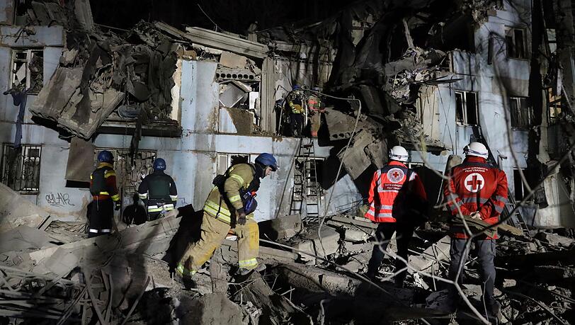 Feuerwehrleute vor einem beschädigten Haus nach dem mutmaßlich russischen Raketenangriff in Saporischschja.