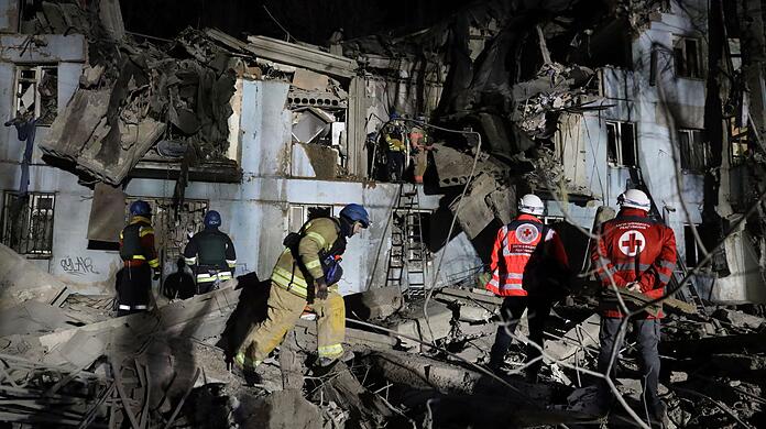 Feuerwehrleute vor einem beschädigten Haus nach dem mutmaßlich russischen Raketenangriff in Saporischschja.
