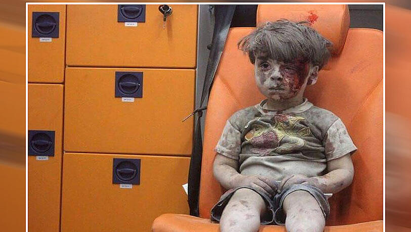 Mit blutverschmiertem Gesicht sitzt ein fünfjähriger Junge in einem Krankenwagen, nachdem ein Haus bei einem Luftangriff in Aleppo zerstört worden war. Mit blutverschmiertem Gesicht sitzt ein fünfjähriger Junge in einem Krankenwagen, nachdem ein Haus bei einem Luftangriff in Aleppo zerstört worden war.