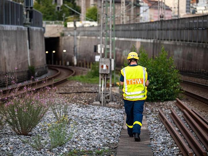 Eine Einsatzkraft vom Technischen Hilfswerk geht neben den S-Bahngleisen. Foto: Lino Mirgeler