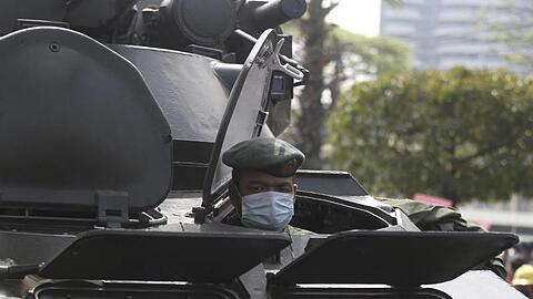 Ein Soldat schaut in Rangun aus einem gepanzerten Militärfahrzeug heraus, das vor dem Gebäude der Zentralbank steht.