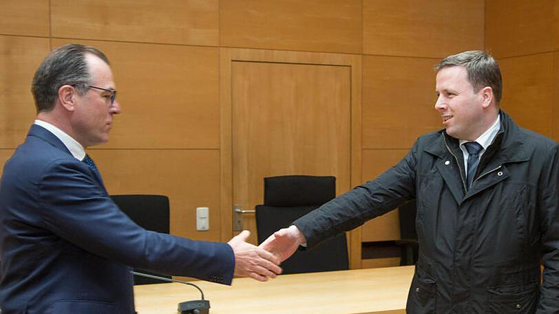 Der Unternehmer Clemens Tönnies (l) begrüßt seinen Neffen Robert Tönnies (r) im Landgericht in Bielefeld mit einem Handschlag.