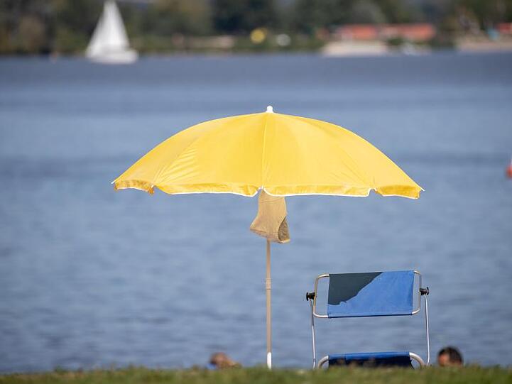 Ein Sonnenschirm steht an einem Strand am Altmühlsee. Tief "Jantra" am Wochenende für einen grundlegenden Wetterwechsel.