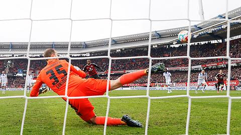 Nürnbergs Kwadwo Duah (M) schießt das 1:1 per Elfmeter, der Karlsruher Torhüter Marius Gersbeck (l) sprang in die falsche Ecke.