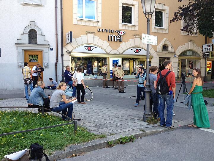 Auf der Straße warten Presseleute auf ein Statement.