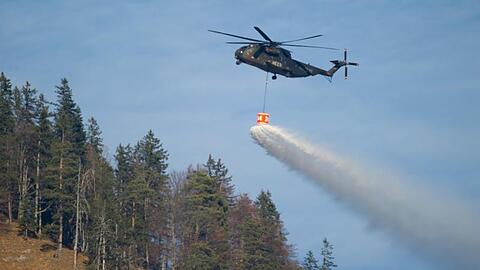 Ein Hubschrauber mit einem Wassertank überfliegt den Schwarzberg. Foto: Sven Hoppe/dpa/Archivbild