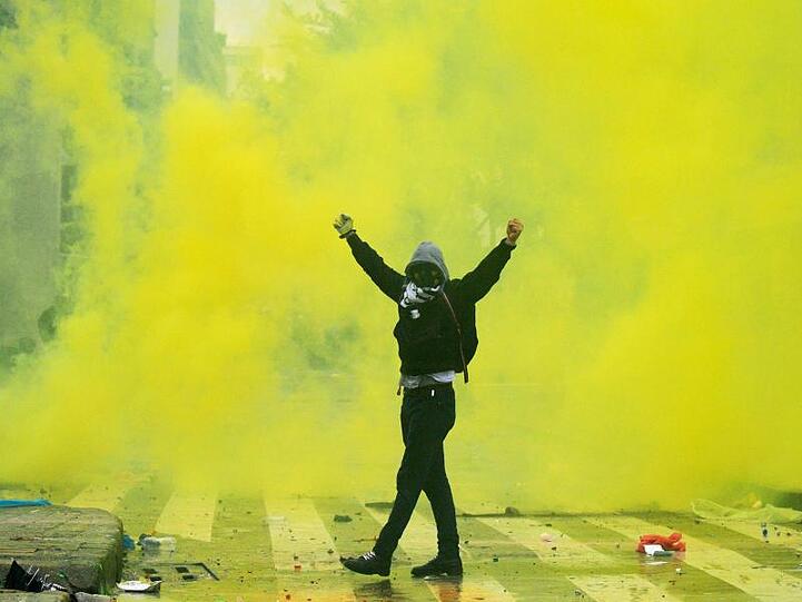 Ein Demonstrant reißt in der Innenstadt von Bogota während eines landesweiten Streiks die Arme hoch.