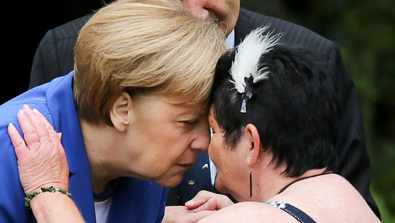 Mit einem traditionellen Maori-Willkommensritual, bei dem die Nasen aneinandergedrückt werden, wird Angela Merkel in Auckland begrüßt. Mit einem traditionellen Maori-Willkommensritual, bei dem die Nasen aneinandergedrückt werden, wird Angela Merkel in Auckland begrüßt.