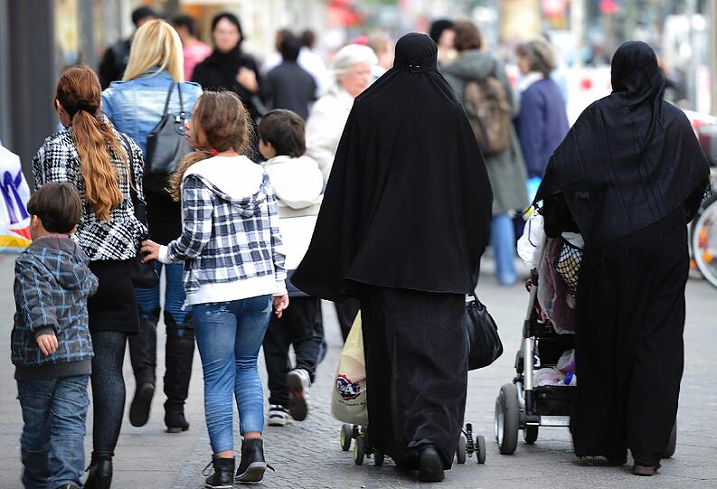 Zwei verschleierte Frauen schieben Kinderwagen durch die Karl-Marx-Straße in Berlin-Neukölln. Wer im Norden des größten Bezirks der Hauptstadt lebt, muss im Alltag nicht einmal Deutsch sprechen.