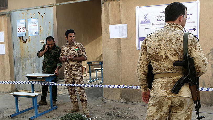 Sicherheitskräfte kontrollieren in Erbil den Eingang eines Wahllokals.