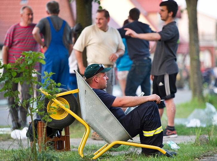 Ein Feuerwehrmann macht am 11.06.2013 in Wust (Sachsen-Anhalt) eine Pause in einer Schubkarre. Viele Ortschaften nahe der Elbe sind vom Hochwasser betroffen.