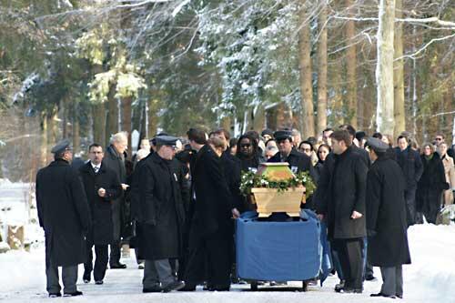 Ein schwerer Gang für die Familie. Der Sarg mit dem adligen Manager wird durch den verschneiten Waldfriedhof getragen.