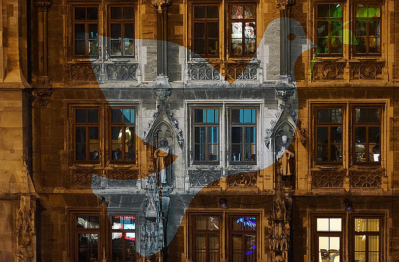 Die Friedentaube, die auf die Rathaus-Fassade projiziert wird, leuchtet die ganze Nacht über.