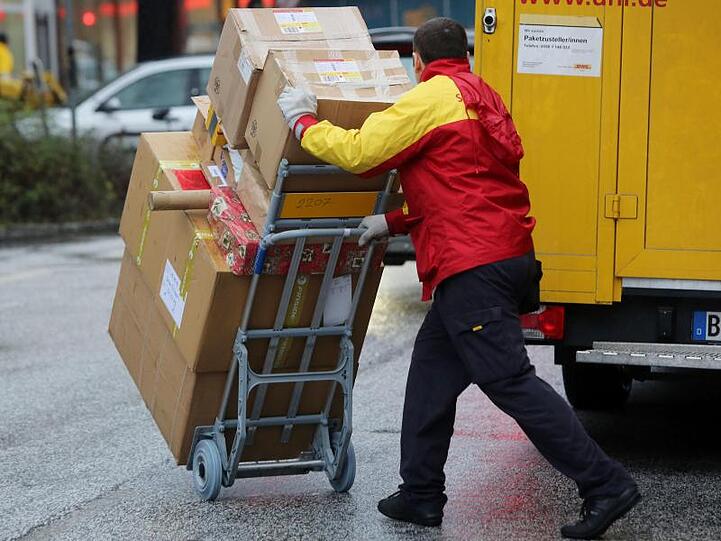 Ein Paketbote von DHL liefert Päckchen aus. Foto: Malte Christians/Archiv