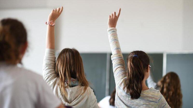 Schüler melden sich während des Unterrichts. Foto: Felix Kästle/dpa
