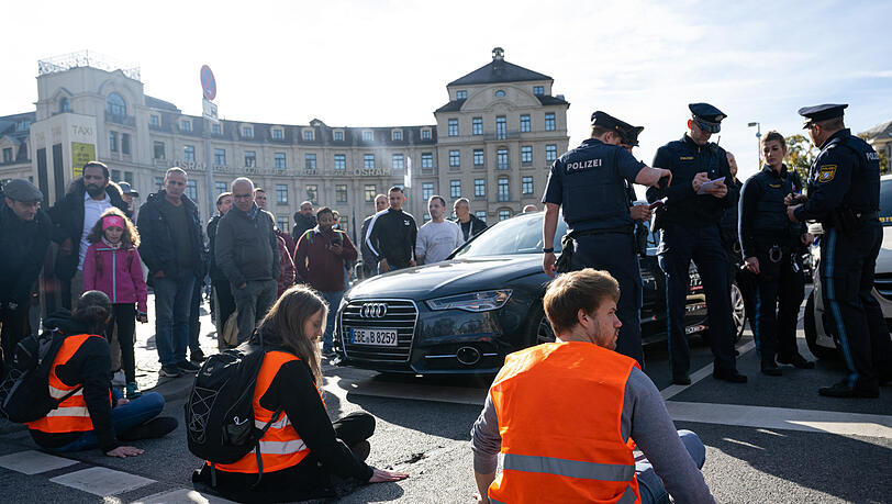 Protestierende hatten sich am Karlsplatz in der Münchner Innenstadt auf die Fahrbahn geklebt und den Verkehr blockiert. Protestierende hatten sich am Karlsplatz in der Münchner Innenstadt auf die Fahrbahn geklebt und den Verkehr blockiert.