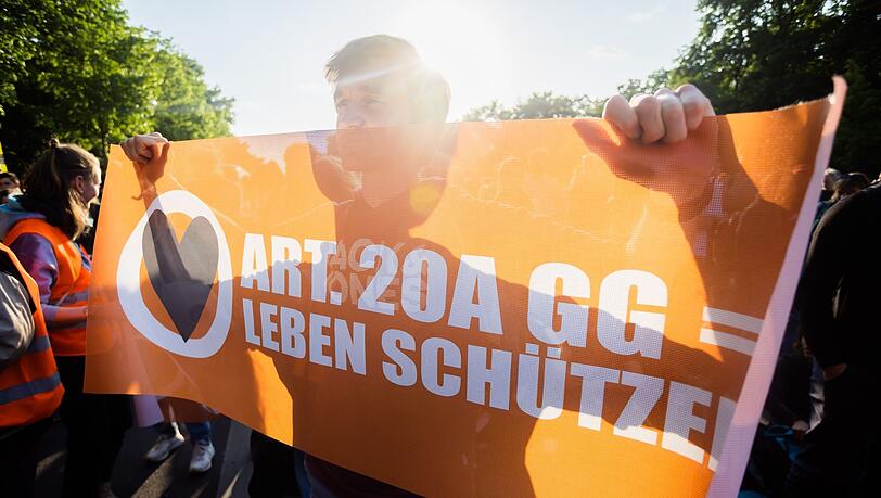 Ein Teilnehmer einer Demonstration der Letzten Generation hält ein Banner.