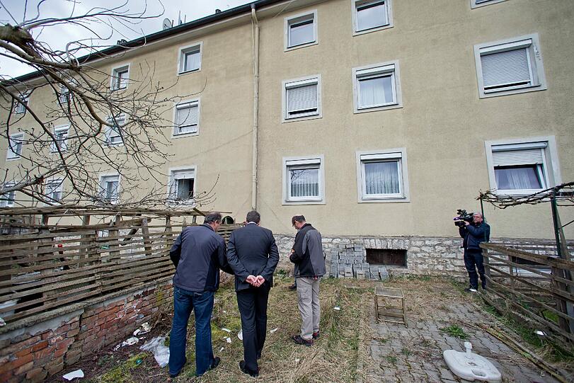 Mitarbeiter der Spurensicherung stehen vor dem Mehrfamilienhaus in Treuchtlingen.