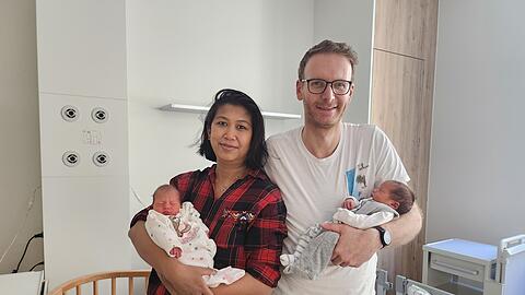 Die stolzen Eltern Duongmani und Andreas Rachinger mit ihren besonderen Zwillingen Ella (links im Bild) und Emma. Die zweieiigen Zwillinge haben an zwei verschiedenen Tagen Geburtstag – obwohl sie mit nur 12 Minuten Abstand geboren wurden.
