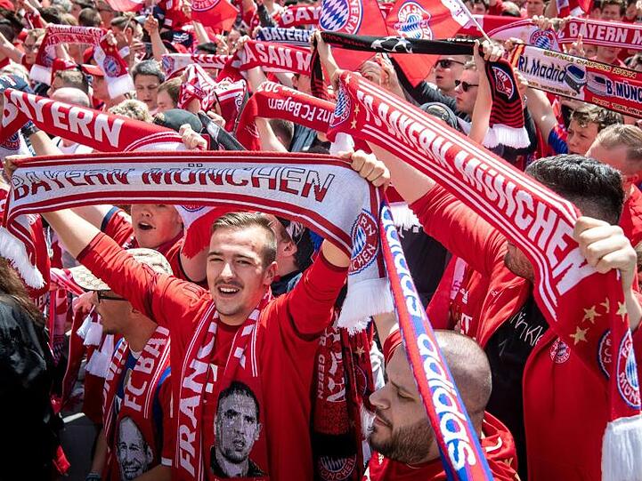Die Fans des FC Bayern München feiern vor dem Rathaus am Marienplatz das Team.