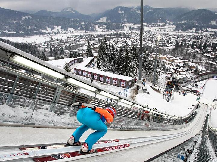 Eine Skispringerin fährt in Oberstdorf die Skischanze hinunter. Foto: picture alliance / dpa / Archivbild