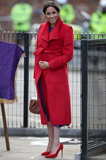 Herzogin Meghan kommt zu ihrem ersten Termin mit Ehemann Harry im Jahr 2019 anlässlich der Enthüllung einer Skulptur am Hamilton Square in einem farbenfrohen Outfit. Zu dem lilafarbenen Kleid trägt die Herzogin einen Mantel in knalligem Rot.