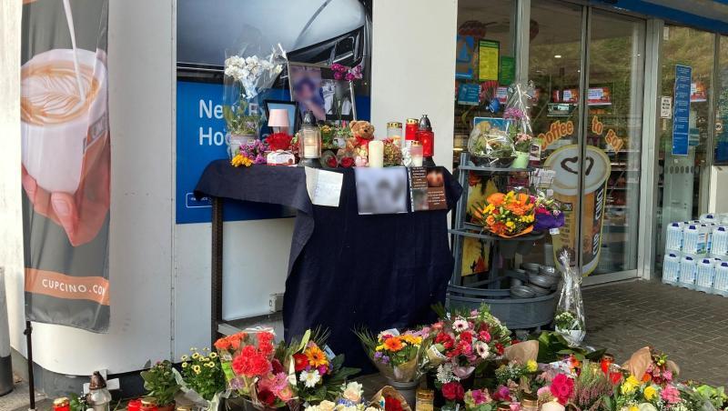 Menschen haben Blumen und Kerzen am Tatort abgelegt.