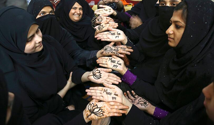 Indische moslemische Frauen posieren für ein Foto. Mit ihren Händen, die mit Henna geschmückt sind, zeigen sie ihre Unterstützung für Bharatiya Janata. Die Parlamentswahlen in Indien werden in neun Phasen zwischen dem 07. April und 12. Mai 2014 stattfinden.