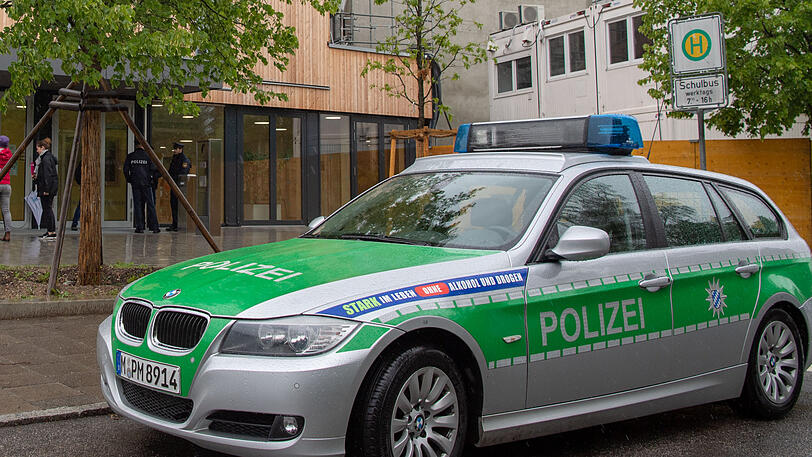 Ein Streifenwagen der Polizei steht vor einer Schule (Symbolbild).