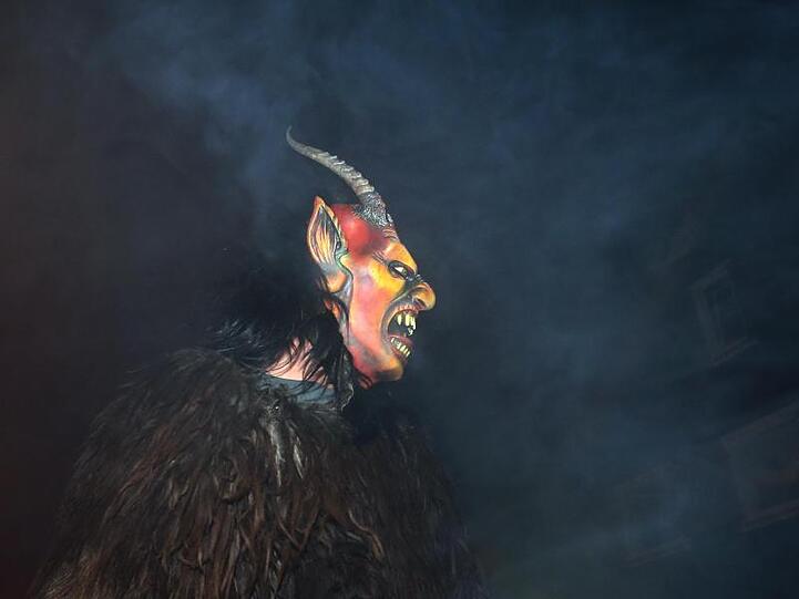 Teilnehmer der Veranstaltung "Börwang brennt" ziehen mit Masken durch einen Ort. Foto: Karl-Josef Hildenbrand/dpa/Archivbild