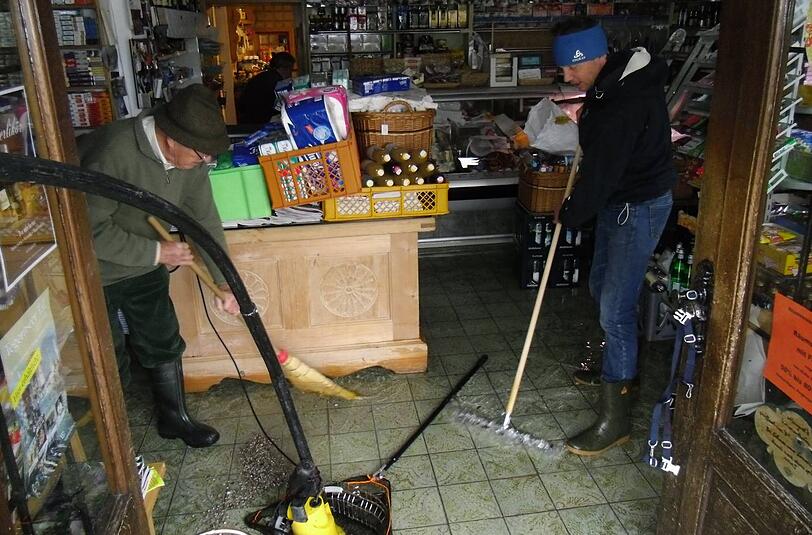 In diesem Laden greifen Hugo P. (li.) und Johannes M. zu Schaufel und Besen und versuchen, das Wasser rauszukehren.