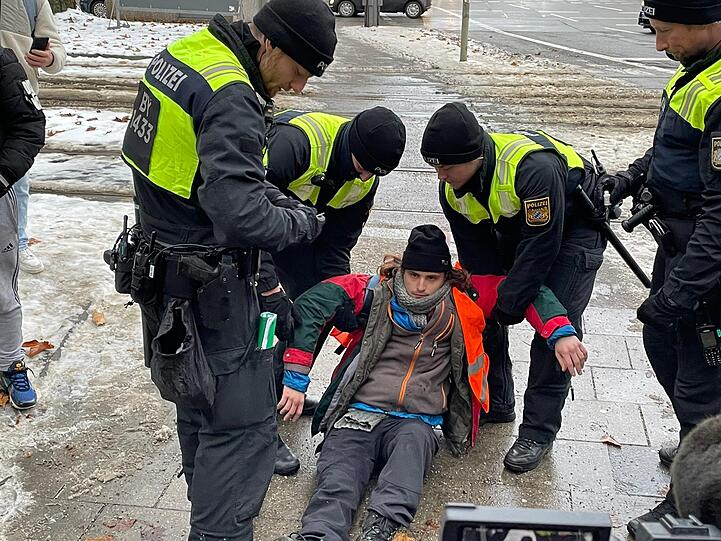 Ein Aktivist der Gruppe "Letzte Generation" wurde von der Polizei am Dienstag, 20.12.2022 am Festkleben auf der Straße gehindert.