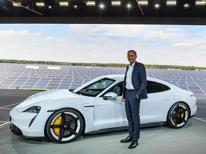 Vorstandsvorsitzender Oliver Blume vor einem Elektromodell des Porsche Taycan.