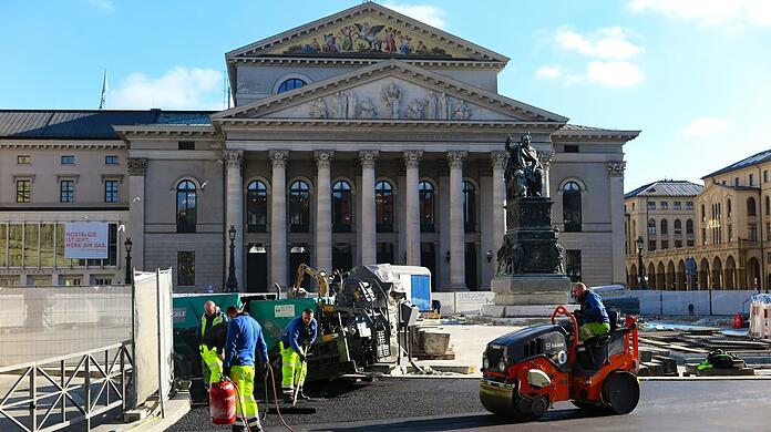Die alten Isarkiesel sind herausgerissen, gerade asphaltieren Bauarbeiter den Platz vor der Oper. Er soll fußgängerfreundlicher werden.