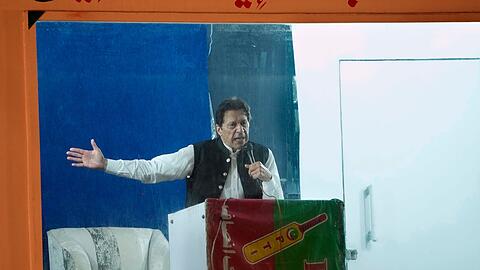 Geschützt durch eine kugelsichere Barriere spricht Imran Khan bei einer Kundgebung in Lahore. Pakistans Ex-Premierminister ist wegen Ermittlungen in einem Korruptionsverfahren in Islamabad verhaftet worden.