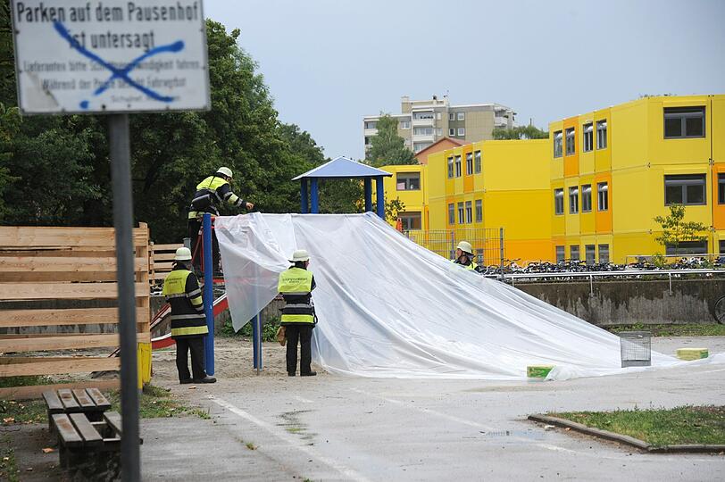 Sprengstoffexperten des Landeskriminalamtes entschärfen die kritische Substanz unter einer Plane im Schulhof.