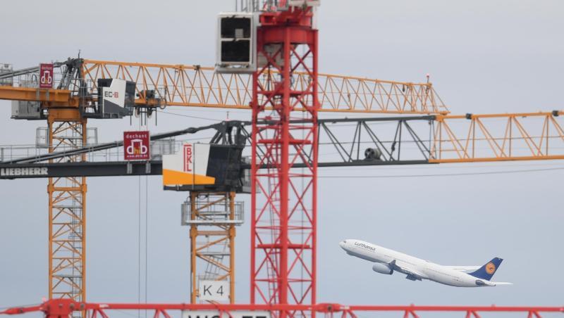 Eine Passagiermaschine der Lufthansa startet auf dem Frankfurter Flughafen hinter Baukränen. Eine Passagiermaschine der Lufthansa startet auf dem Frankfurter Flughafen hinter Baukränen.
