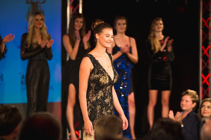Sichtlich glücklich nimmt die Zweitplatzierte im transparenten Spitzenkleid ihren Preis entgegen.