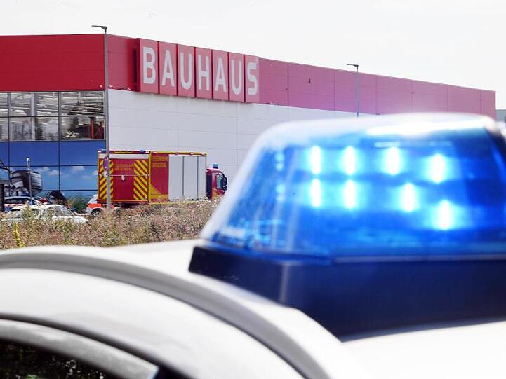 Einsatzfahrzeuge der Feuerwehr stehen vor dem Baumarkt.