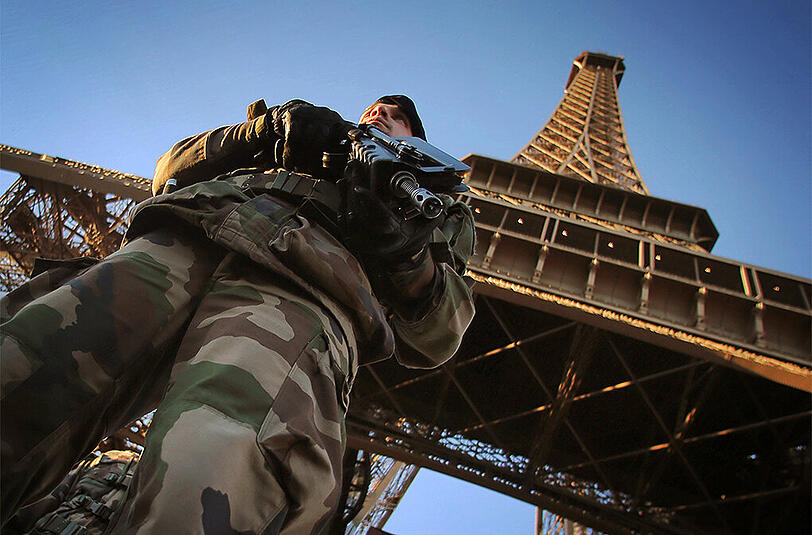 Ein Soldat steht vor dem Eiffelturm in Paris. Die Sicherheitsvorkehrungen sollen im ganzen Land immens verstärkt werden.