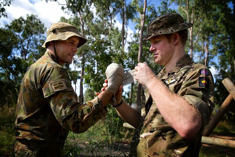 Auch Verarzten will gelernt sein. Prinz Harry verbindet die Hand von Lieutenant Gerard Hinchliffe.