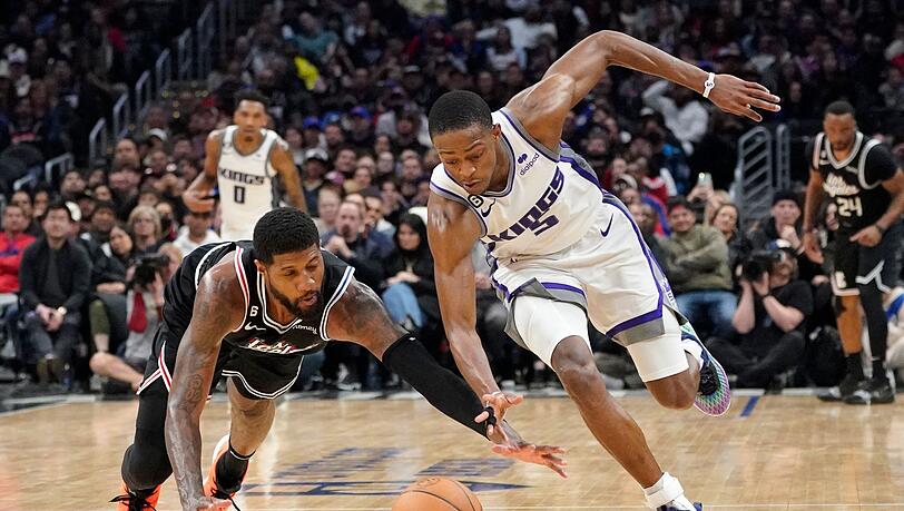 Clippers-Forward Paul George (l) und De'Aaron Fox von den Kings kämpfen um den Ball.