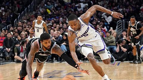 Clippers-Forward Paul George (l) und De'Aaron Fox von den Kings kämpfen um den Ball.