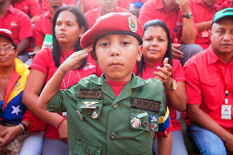 Ein kleiner Juge in Militäruniform salutiert in Caracas zu Ehren des Venezuelanischen Präsidenten Nicolas Maduro, der genau seit einem jahr im Amt ist. Nicht viele Venezuelander unterstützen so ihren Präsidenten. Seit Februar 2014 toben in Venezuela Proteste gegen die Regierung.