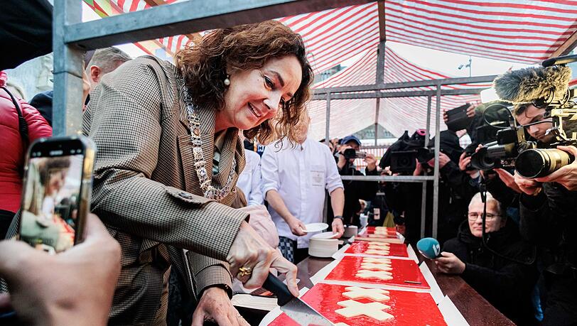 Amsterdams Bürgermeisterin Femke Halsema schneidet die lange Torte an. Amsterdams Bürgermeisterin Femke Halsema schneidet die lange Torte an.
