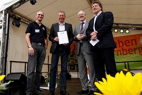 Nürnbergs OB Ulrich Maly mit der &bdquo;Fairtrade Town&ldquo;-Urkunde, die ihm Heinz Fuchs (re.) Chef von Transfair) überreichte, auch Frank Braun (li.). und Stadtdekan Michael Bammessel (2.v.re) freuen sich.