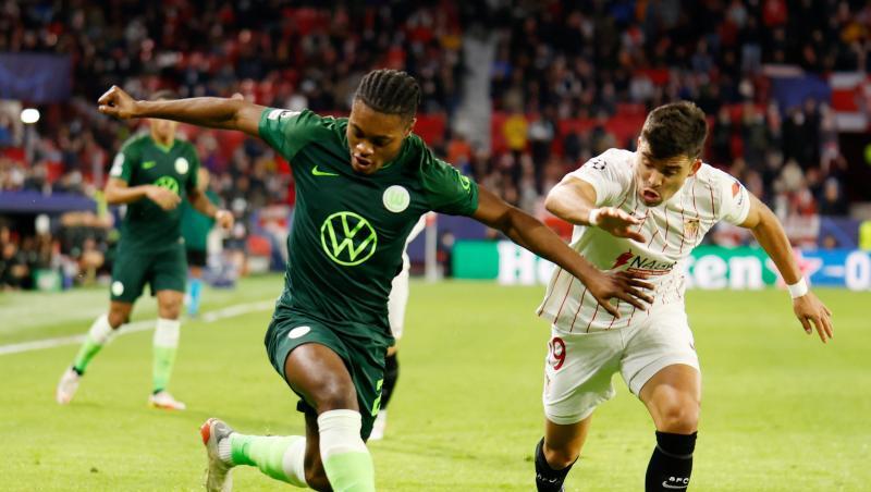 Wolfsburgs Mittelfeldspieler Ridle Baku (l) behauptet sich gegen Sevillas Marcos Acuna. Wolfsburgs Mittelfeldspieler Ridle Baku (l) behauptet sich gegen Sevillas Marcos Acuna.