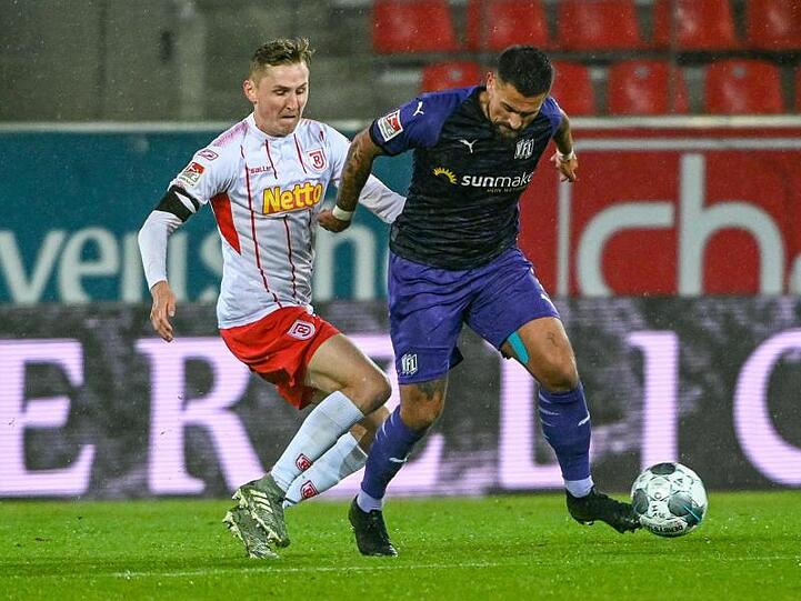 Marc Lais von Regensburg (l.) und Marcos Alvarez von Osnabrück kämpfen um den Ball. Foto: Armin Weigel/dpa