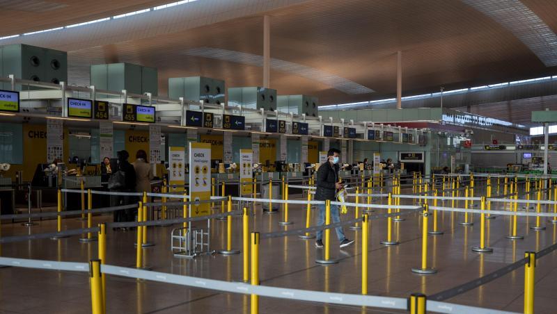 Ein Mann mit Mundschutzmaske im leeren Terminal eines Flughafens. Ein Mann mit Mundschutzmaske im leeren Terminal eines Flughafens.